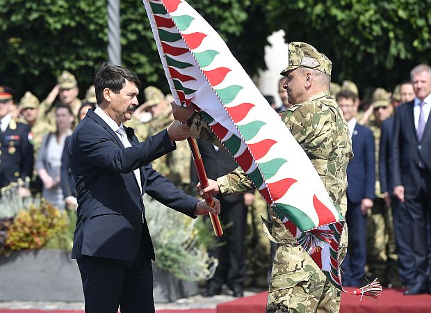 A képen: Áder János átadja a Magyar Honvédség Parancsnokságának adományozott csapatzászlót Korom Ferenc altábornagynak, a Honvéd Vezérkar főnökének az ünnepségen.